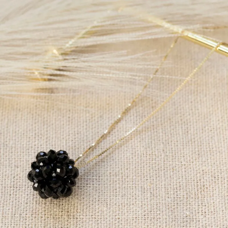 Ball-shaped black bead pendant with gold hanger
