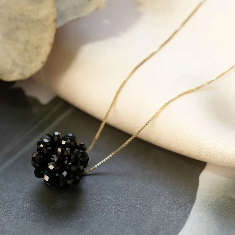 Ball-shaped black bead pendant with gold hanger